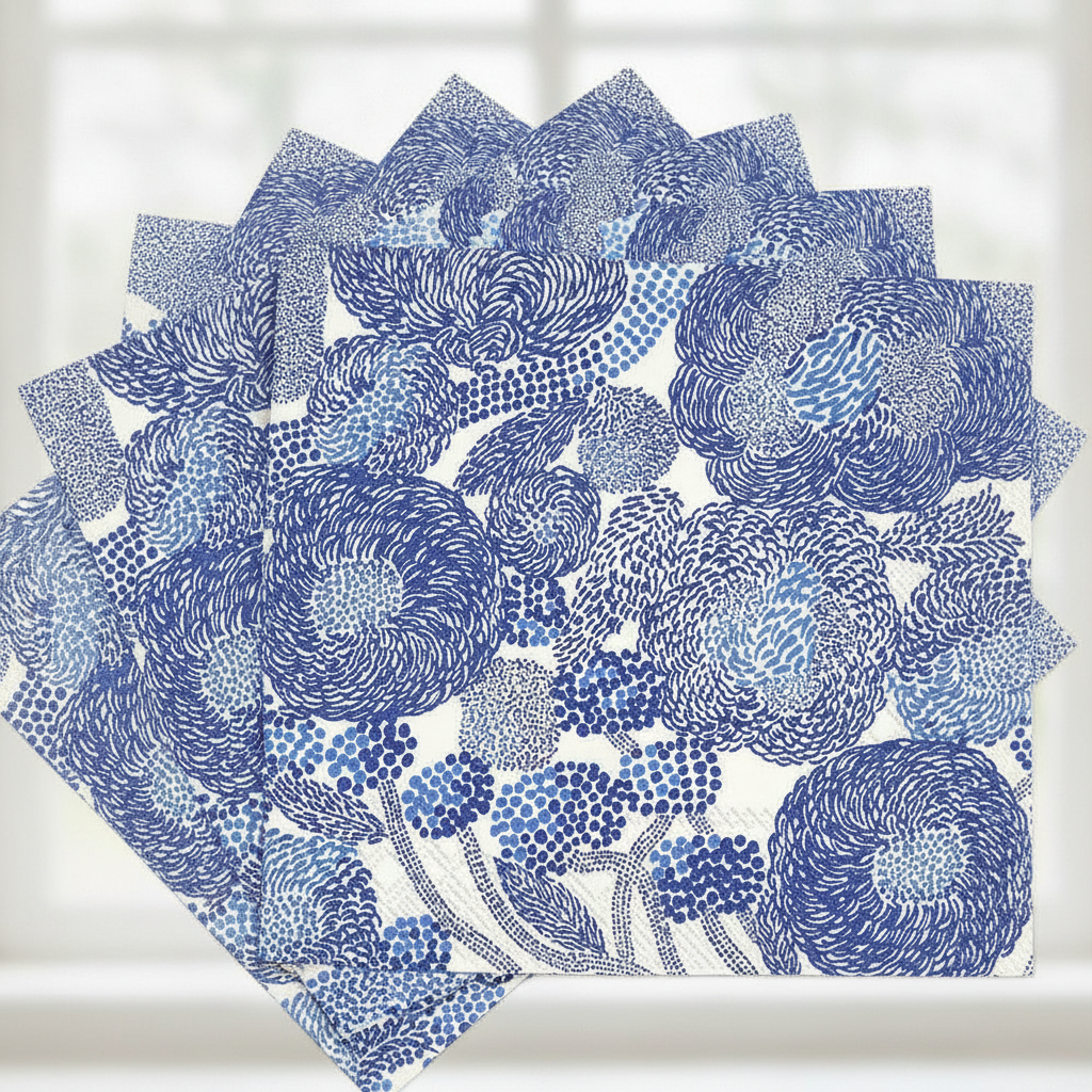 Close-up of fanned cream and blue Scandinavian floral paper napkins