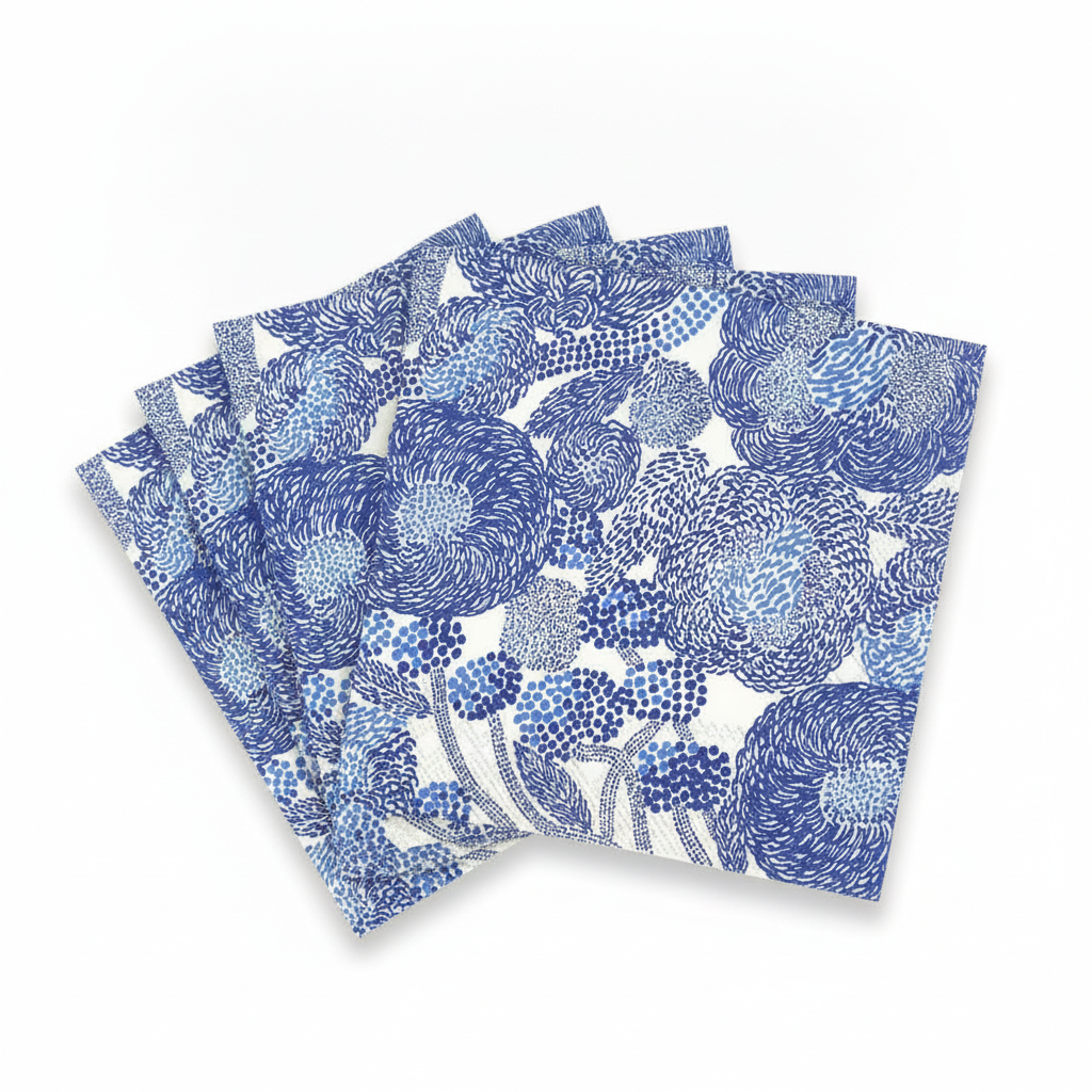 Scandinavian floral paper lunch napkins in cream and indigo blue, fanned stack on white