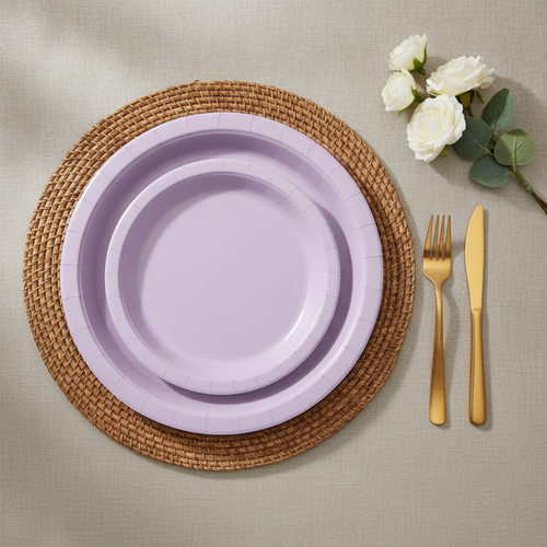 Lavender disposable paper party plates — thin matte uncoated light purple paper dinner and dessert plates on a woven rattan placemat with gold flatware and white roses