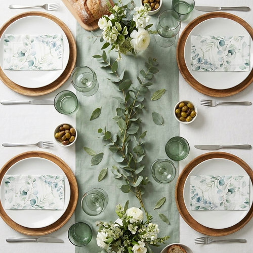 Fresh sage and eucalyptus garden brunch table setting with botanical print napkins, silver cutlery, and eucalyptus stems