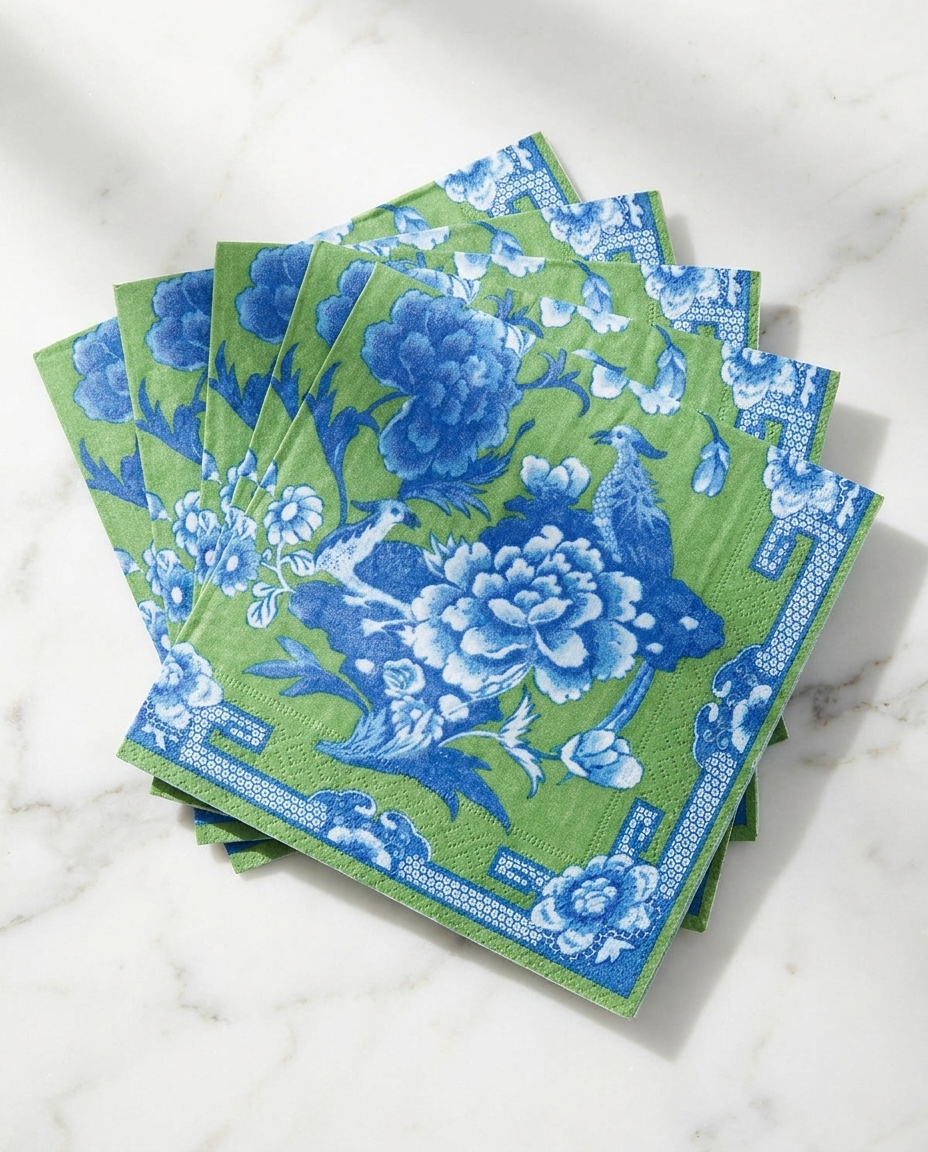 Green and blue cocktail napkins fanned out on marble showing full artistic pattern design