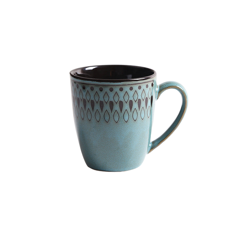Vintage teal geometric stoneware mug on white background — intricate dot-and-diamond pattern with dark interior
